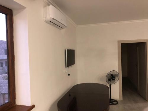 um quarto com uma televisão e uma ventoinha na parede em Ha-Li em Argavand