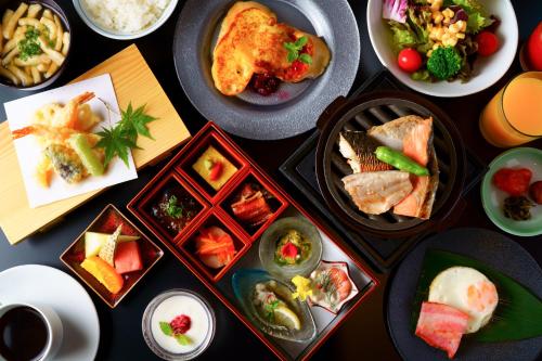 uma mesa com muitos pratos de comida em Grandvrio Hotel Miyajima Wakura - ROUTE INN HOTELS - em Hatsukaichi