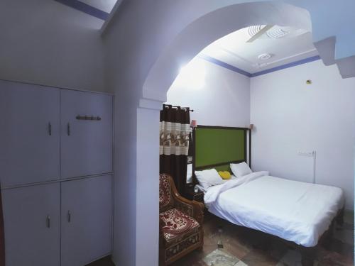 sypialnia z łóżkiem i krzesłem w obiekcie Eastern Gate Homestay w mieście Khajuraho