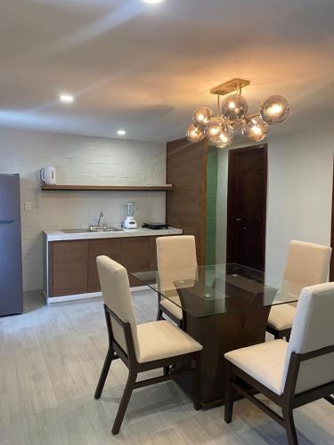 a dining room with a glass table and chairs at Casa Lily in Orizaba