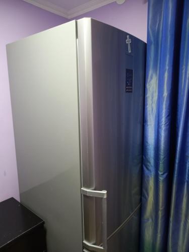 a stainless steel refrigerator in a room with a blue curtain at Tskaltubo Guest House On Mirian Mepe in Tskaltubo