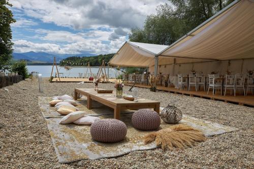 a tent with a table and chairs and a lake at Mobilný domček na brehu Liptovskej Mary in Hliník