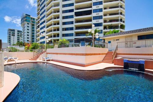 a swimming pool in front of a building at Aquarius Luxury Apartment in Cairns