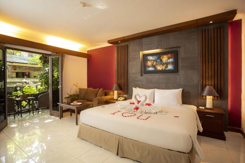 una camera da letto con un grande letto con un arco sopra di Risata Bali Resort & Spa a Kuta