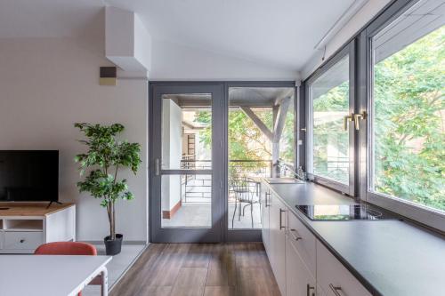 een keuken met witte kasten en een groot raam bij Rustic Central Studios by LH in Boedapest