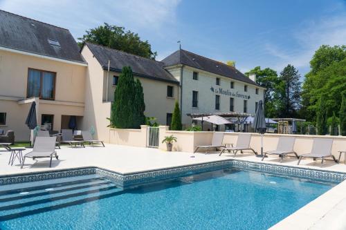 a swimming pool in front of a building at Domaine de Presle Saumur, The Originals Relais in Distr&eacute;