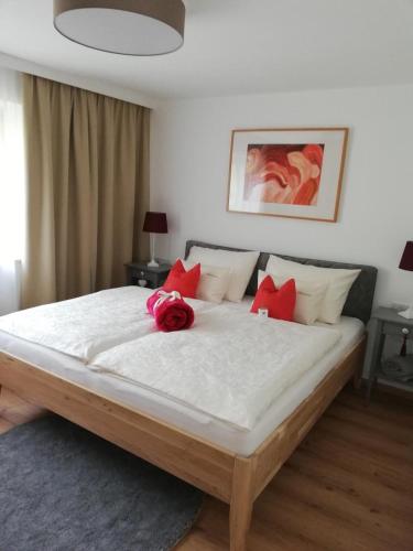 a bedroom with a large bed with a pink rose on it at Dreilärchenhaus in Brixen im Thale