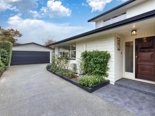 a house with a driveway and a garage at The Airport Homestay House in Christchurch