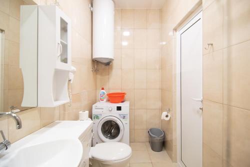 a bathroom with a washing machine and a washer at Filaret studios with free parking in Varna City