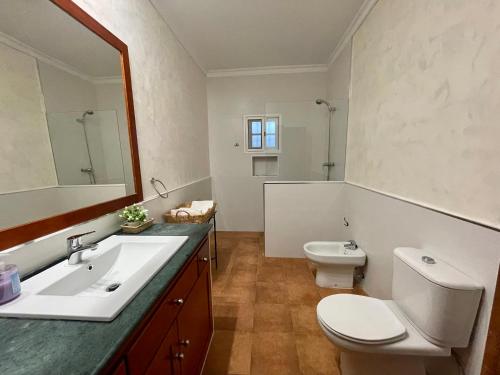 uma casa de banho com um lavatório, um WC e um espelho. em Chalet en la playa de Bolonia em Tarifa