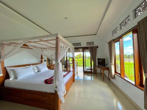 a bedroom with a bed with a canopy at Bhakti Ubud Villa in Ubud