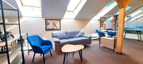 a living room with a couch and blue chairs at Self Check-In Loft in Klaipeda city centre Free Parking in Klaipėda