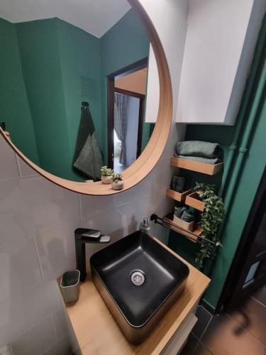 baño con lavabo negro y espejo en Green Apartment Old Town, en Bucarest