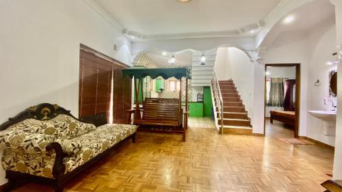 - un salon avec un canapé et un escalier dans l'établissement La Flora kodaikanal, à Kodaikānāl