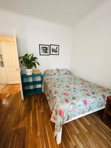 une chambre avec un lit avec un couvre-lit fleuri dans l'établissement Beautiful and spacious apartment in Paris, à Paris