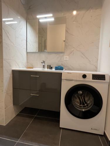 - un lave-linge dans la salle de bains pourvue d'un lavabo dans l'établissement Vivez le panorama à 180 - PARKING - Proximité de la gare, au Havre