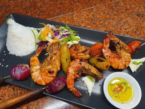 a plate of food with shrimp and vegetables on a table at Takatuka Beach Resort in Sipalay