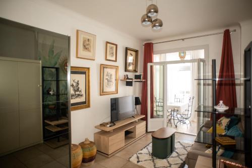 a living room with a tv and a couch at Studio Central in Canet-en-Roussillon