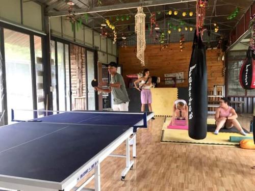 - un groupe de personnes autour d'une table de ping-pong dans l'établissement Amica House, à Sa Pa