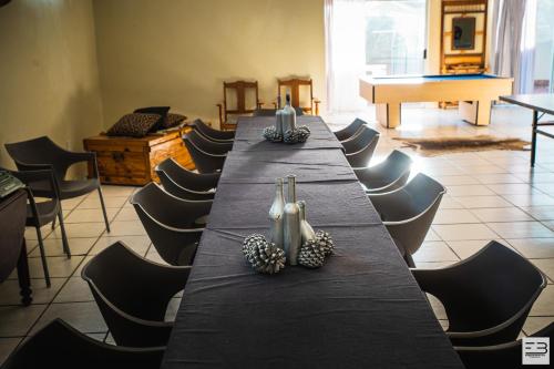 a long table in a room with chairs and a piano at Geluksfontein Private Game Farm in Cullinan