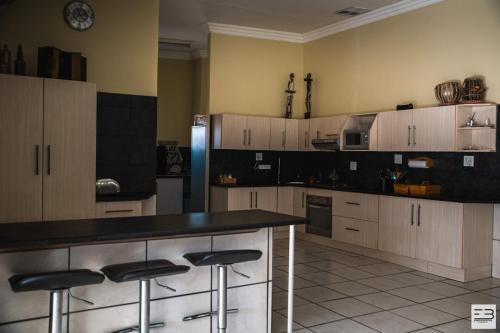 a kitchen with a counter and stools in it at Geluksfontein Private Game Farm in Cullinan