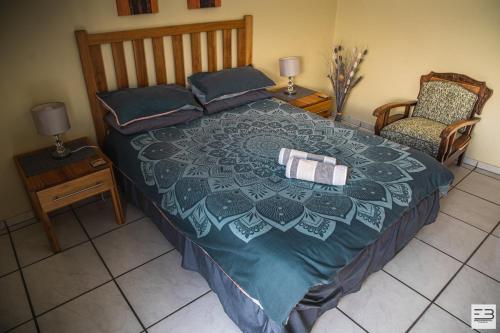 a bedroom with a large bed and a chair at Geluksfontein Private Game Farm in Cullinan