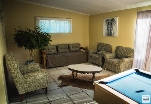 a living room with a couch and a pool table at Geluksfontein Private Game Farm in Cullinan