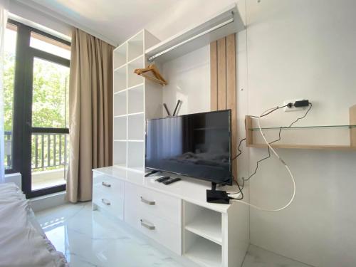 a living room with a tv on a white dresser at The Green Paradise Apartments in Primorsko