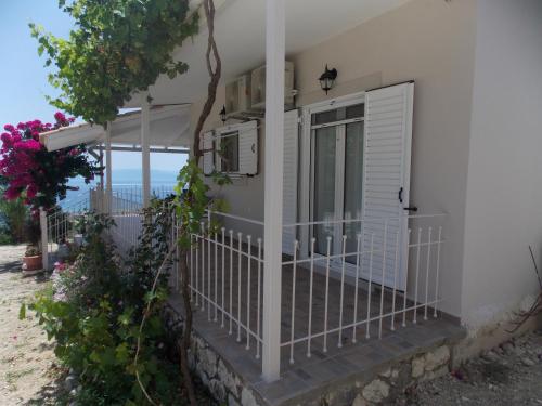 a house with a balcony with a view of the ocean at Vasiliki View in Áyios Pétros