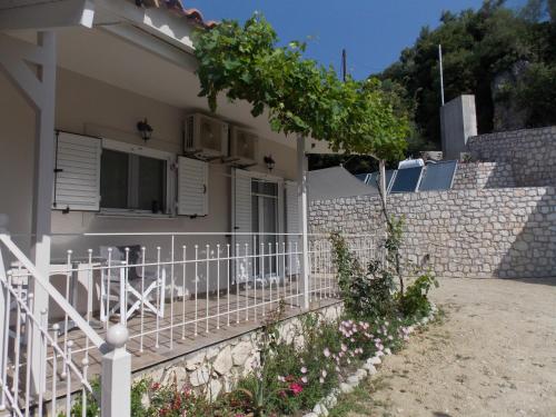 a white fence in front of a house at Vasiliki View in Áyios Pétros