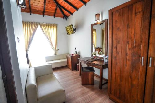 a room with a desk and a chair and a mirror at Hotel Tamarind Tree in Tissamaharama