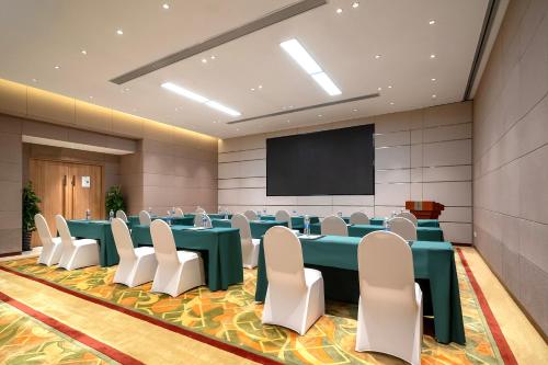 a conference room with tables and chairs and a screen at Holiday Inn Shanghai Hongqiao Central by IHG in Shanghai