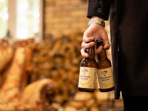 a man holding a bottle of champagne in a store at Tokachi Nakasatsunai Glamping Resort Feriendorf in Naka-satsunai