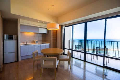 a kitchen and dining room with a view of the ocean at Moon Ocean Ginowan Hotel & Residence in Ginowan