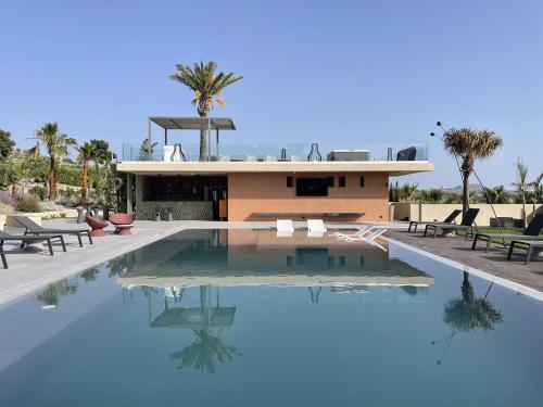 a house with a swimming pool in front of a building at Terreforti Luxury Village in Agrigento