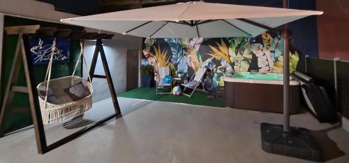 un tavolo con un ombrello e un'altalena di Casa Aroma Di Caffee a Yauco