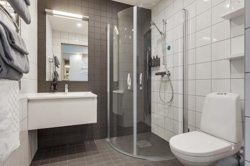 uma casa de banho com um chuveiro, um WC e um lavatório. em Furuvik Havshotell 