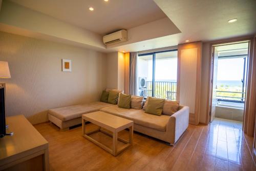 a living room with a couch and a table at Moon Ocean Ginowan Hotel & Residence in Ginowan