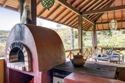 an outdoor oven in a house with a table at Mansão da Imperatriz: Vintage, Termas e Natureza in Santo Amaro da Imperatriz
