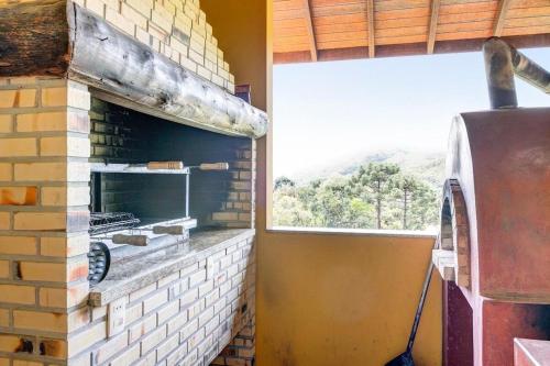 a kitchen with a brick oven and a window at Mansão da Imperatriz: Vintage, Termas e Natureza in Santo Amaro da Imperatriz