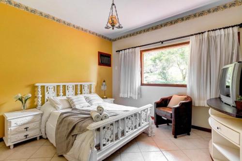 a bedroom with a white bed and a window at Mansão da Imperatriz: Vintage, Termas e Natureza in Santo Amaro da Imperatriz