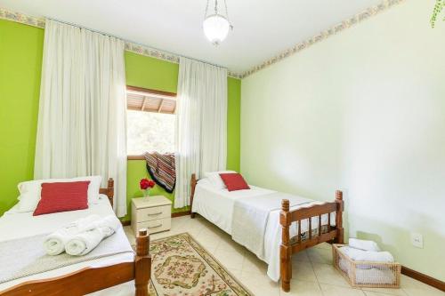 two beds in a room with green walls at Mansão da Imperatriz: Vintage, Termas e Natureza in Santo Amaro da Imperatriz