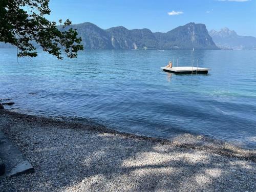 a person sitting on a boat in the water at Villa Bootsmann mit spektakulärer Seesicht nahe Badestrand in Vitznau