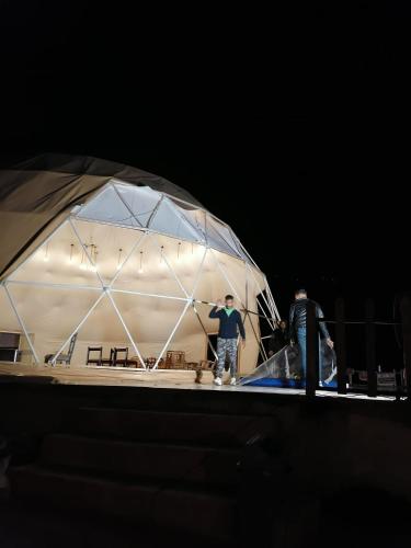 two people standing in a tent at night at Sun Luxury Rum Camp in Wadi Rum