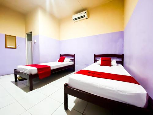 Palopo的住宿－RedDoorz near Terminal Dangerakko Palopo，一间卧室配有两张红色和白色床单