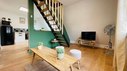 a living room with a table and a staircase at Appartement La Cabane de la Baie. in Étaples