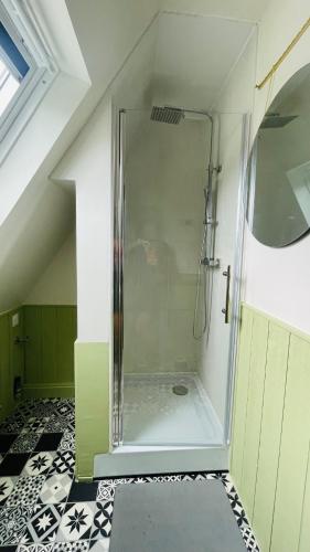 une douche avec une porte vitrée dans une salle de bain dans l'établissement Appartement La Cabane de la Baie., à Étaples