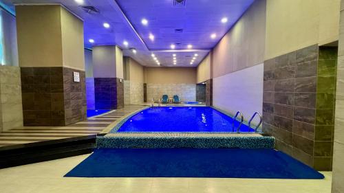 a large swimming pool in a building with a blue tub at Centaurus Apartment City View Three Beds in Islamabad