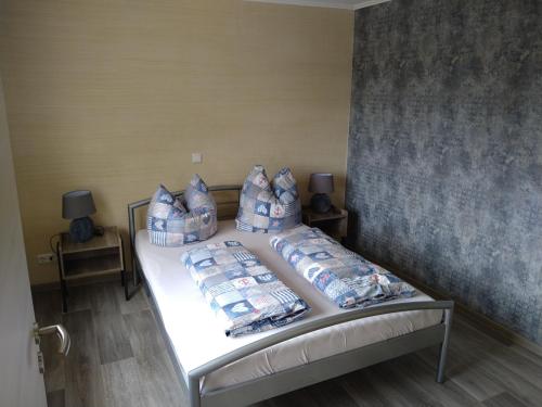 Schlafzimmer mit einem Bett mit blauen und weißen Kissen in der Unterkunft Ferienhaus Opolka in Balgstädt