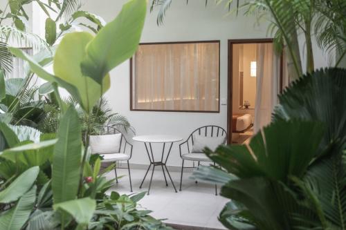 a room with a table and chairs and plants at Plantation Urban Resort & Spa in Phnom Penh